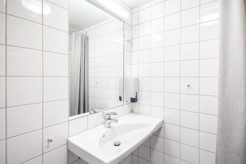 ein weißes Badezimmer mit Waschbecken und Spiegel in der Unterkunft Bunks at Rode in Oslo