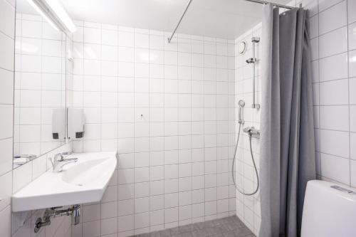 ein weißes Badezimmer mit Waschbecken und Dusche in der Unterkunft Bunks at Rode in Oslo