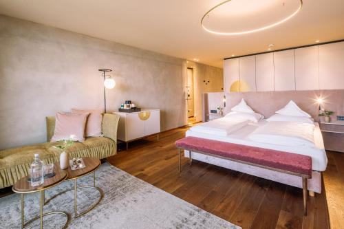 ein Schlafzimmer mit einem großen Bett und einer Couch in der Unterkunft Hotel Hohenwart in Schenna