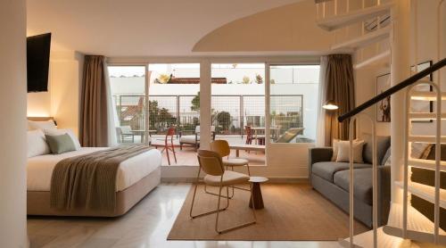 a hotel room with a bed and a living room at Limehome Madrid Sol in Madrid