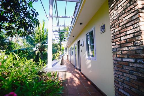an empty hallway of a house with a brick wall at Veranda Resort Phan Thiết in Tiến Thành