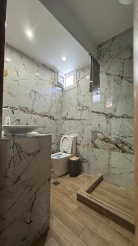 a bathroom with a toilet and a sink at J&B Suites in Kavála