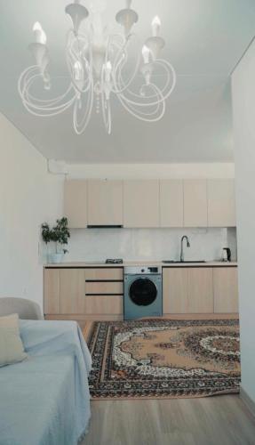 a kitchen with a bed and a chandelier at Парус in Cholpon-Ata