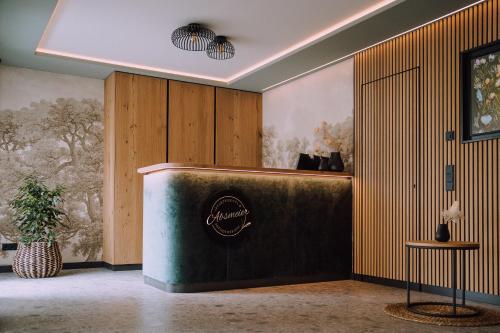a lobby with a counter with a sign on the wall at Appartementhaus Absmeier in Bad Füssing