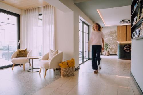 a woman is walking through a living room at Appartementhaus Absmeier in Bad Füssing
