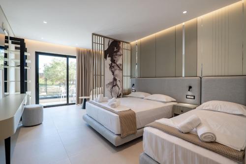 a bedroom with two beds and a large window at Marea Suites Borsh in Borsh