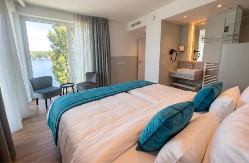 a bedroom with a large bed with a large window at H24 Hotel Berlin Grünau in Berlin