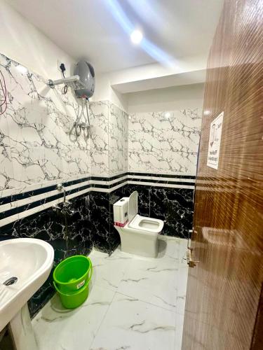 a bathroom with a sink and a toilet in a room at Hotel Tu Casa in Kolkata