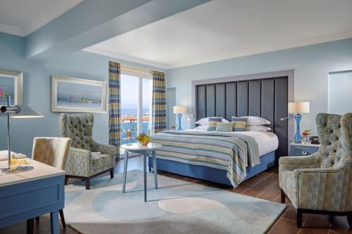 a bedroom with a large bed and two chairs at The Eliott Hotel in Gibraltar