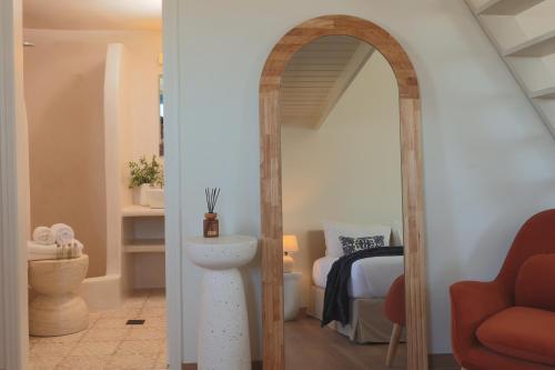 a room with a mirror and a room with a bed at White Pearl Laokasti Suites in Oia