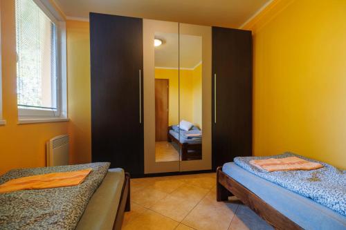a bedroom with two beds and a mirror at Pastvinka in Pastviny