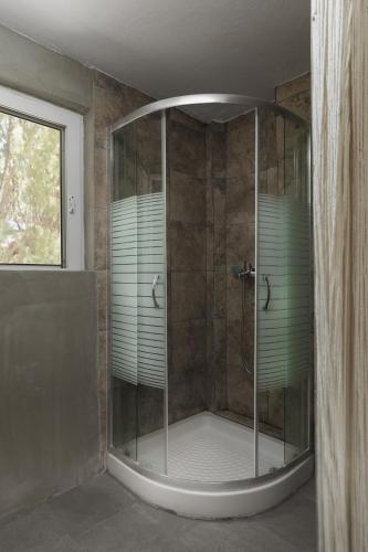 a shower with a glass enclosure in a bathroom at Mazi in Sifnos in Sifnos