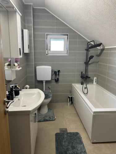 a bathroom with a sink and a tub and a toilet at Sarajevo Villa Oasis in Doglodi