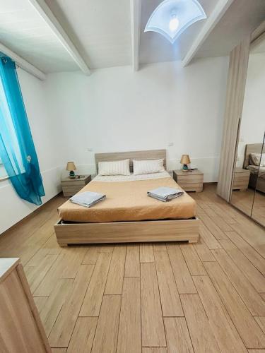 a bedroom with a large bed and a wooden floor at Il Quarzo in Càbras