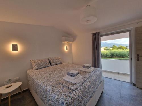 a bedroom with a bed and a large window at Sea & Olive Retreat in Zipárion