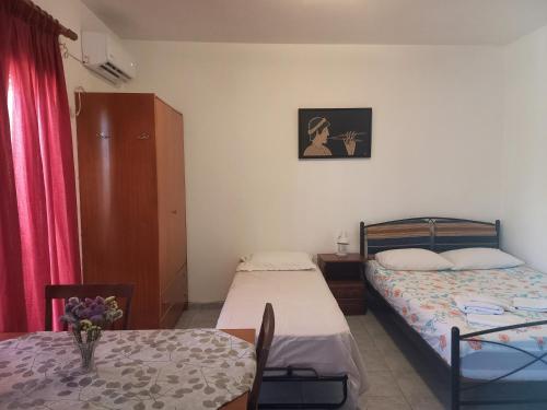 a small room with two beds and a table with a tableablish at Apartment Kasperakos in Skiathos