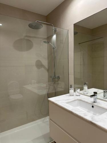 a bathroom with a white sink and a shower at Perola Mar in Nazaré