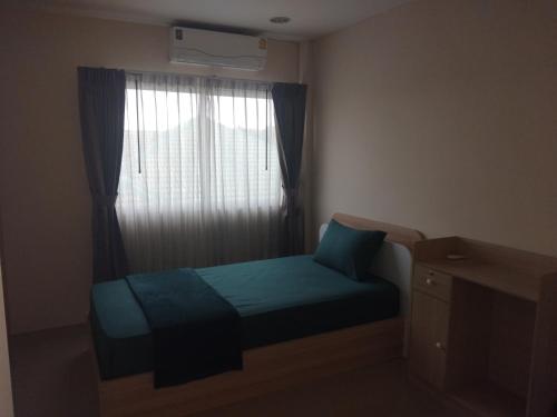 a small bedroom with a bed and a window at Sunset Groove Cafe in Nong Prue