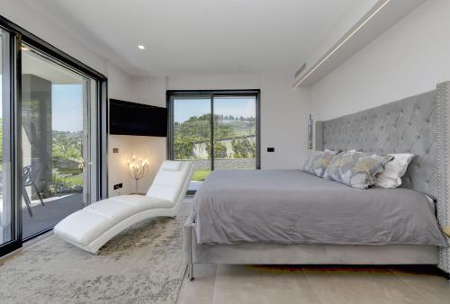 a bedroom with a large bed and a large window at Villa Casara Design and Relax Lago di Garda in Costermano