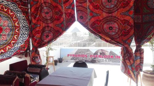 a room with curtains and a table and chairs at Pyramids Overlook Inn in Cairo