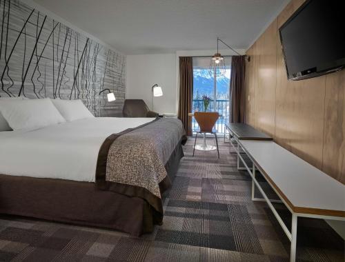 a hotel room with a large bed and a desk at Coast Canmore Hotel & Conference Centre in Canmore