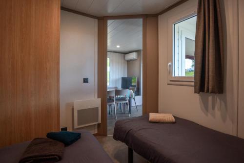 a small room with two beds and a window at Chalet Etxean in Hasparren