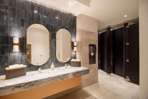 a bathroom with two sinks and two mirrors at Coast Canmore Hotel & Conference Centre in Canmore