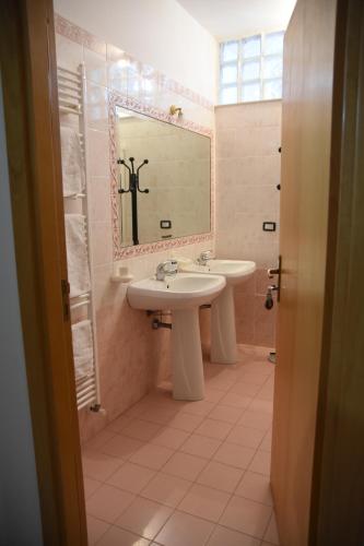 a bathroom with two sinks and a mirror at B&B Salento Vacanze in Maglie