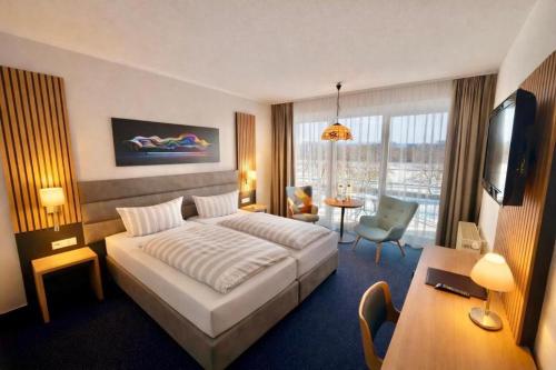 a hotel room with a bed and a living room at Turmhotel Schwedt in Schwedt