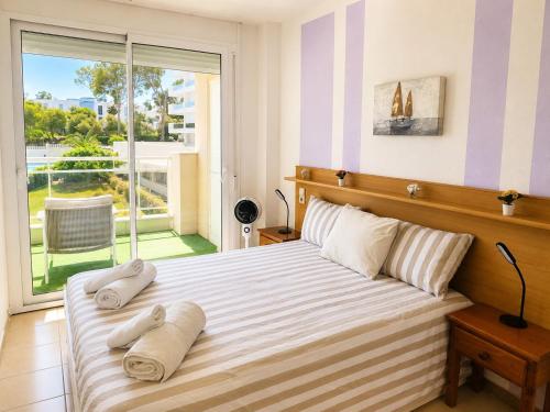 a bedroom with a large bed with towels on it at Salou Beach Apartment with private Pool in Salou