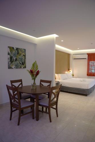 a living room with a table and chairs and a bed at Albrook Inn in Panama City