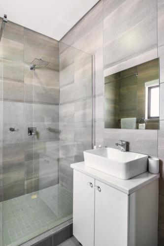 a bathroom with a sink and a glass shower at Emirates Hotel in Ondangwa