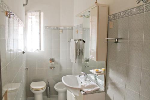 Baño blanco con lavabo y aseo en Nonna grazia, en Roma