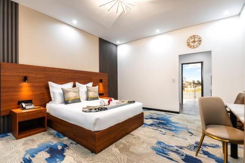 a bedroom with a large bed and a table and chairs at Emirates Hotel in Ondangwa