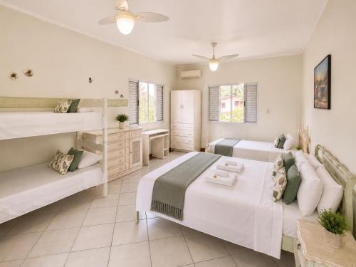 a bedroom with two beds and a couch at Pousada Casa Contos de Minas in Ubatuba