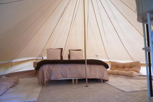 a bedroom with a bed in a tent at Nuit au Ranch Horse Paradise & Jacuzzi in Boutigny-sur-Essonnes