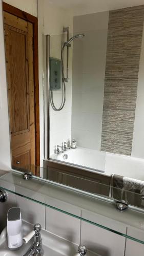 a bathroom with a sink and a mirror at Balmungo Cottage B&B in St. Andrews