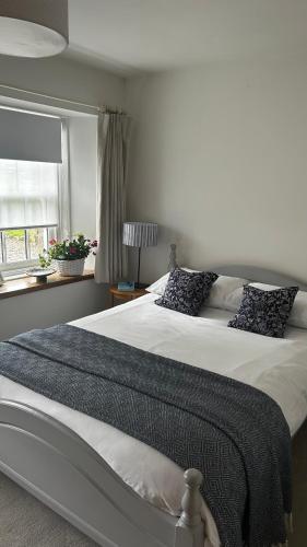 a bedroom with a large bed and a window at Balmungo Cottage B&B in St. Andrews