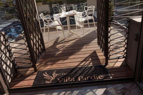 a wooden deck with a table and chairs at Villa Birdie Boutique - Adults Only in Donostia-San Sebastián