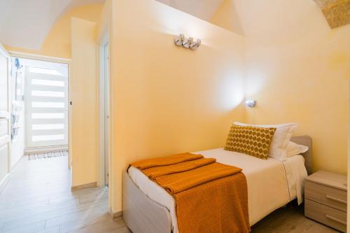 a bedroom with a bed with an orange blanket on it at Arco Suite - Lecce Selection in Lecce
