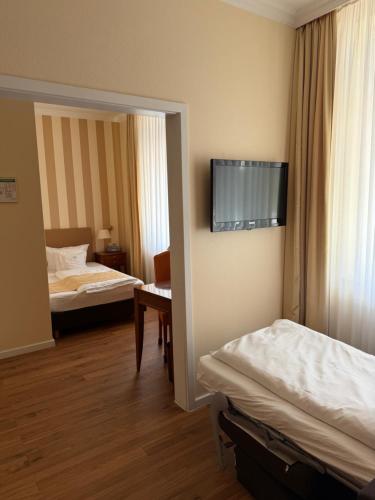 a hotel room with two beds and a mirror at Hotel Savoy Hannover in Hannover