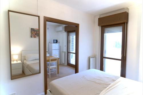 a bedroom with a mirror and a bed and a desk at Appartamento con veranda tra Roma e il mare in Vitinia