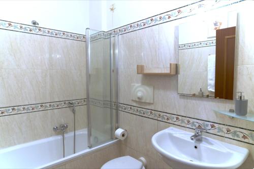 a bathroom with a sink and a shower and a toilet at Appartamento con veranda tra Roma e il mare in Vitinia