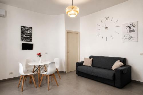 a living room with a couch and a table and a clock at Maison Alexeur - Intero Appartamento in Crotone