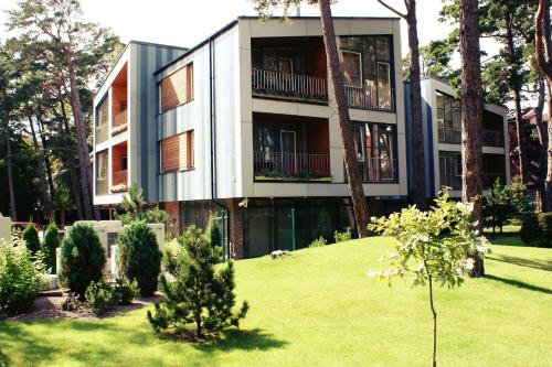 a large building with a yard with trees and a building at Guest House Aštuoni in Palanga