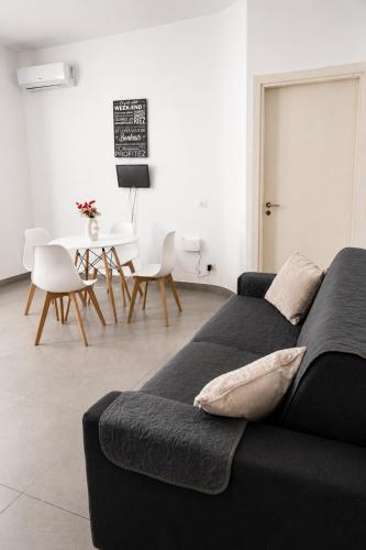 a living room with a black couch and a table at Maison Alexeur - Intero Appartamento in Crotone