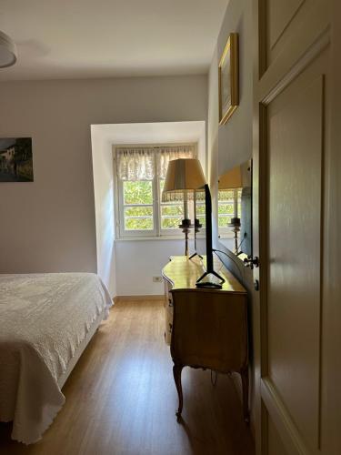 a bedroom with a bed and a lamp on a dresser at La Contessa - Lenno in Lenno