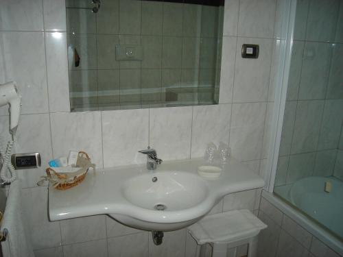 a bathroom with a white sink and a mirror at Hotel Le Palme in Gioia Tauro