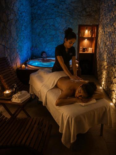 a woman giving a man a massage on a bed at SPA ROOM SICILIA - Suite con Spa ad uso esclusivo Jacuzzi Sauna Hammam in Rosolini