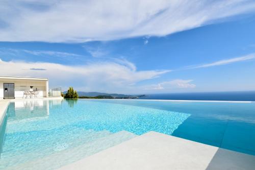 an infinity pool with a view of the ocean at Apiron Luxury Villa in Agía Kyriakí